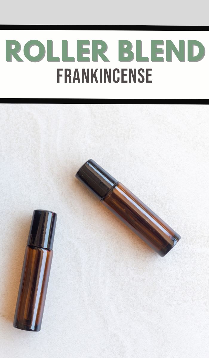 Two brown roller bottles with black caps rest on a light surface, labeled ROLLER BLEND FRANKINCENSE. Ideal for those interested in crafting a DIY Frankincense roller blend, these bottles offer an inviting canvas for your aromatic creations.