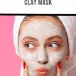 A person with a towel on their head applies a clay mask on their face. They are touching their cheeks with their fingers, indulging in the Frankincense Clay Mask. Above, text reads FRANKINCENSE CLAY MASK against a pink background.