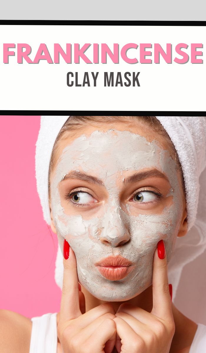 A person with a towel on their head applies a clay mask on their face. They are touching their cheeks with their fingers, indulging in the Frankincense Clay Mask. Above, text reads FRANKINCENSE CLAY MASK against a pink background.