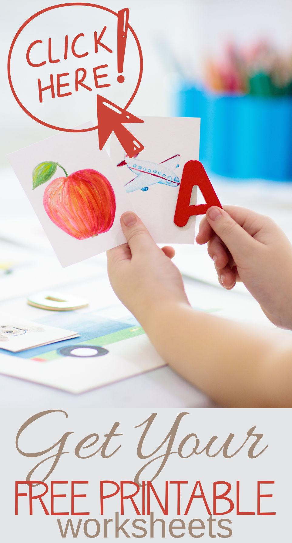 A child holds a card with a red apple and the letter A. A red arrow and text say Click Here! Below, text reads Get Your Free Printable Worksheets. Colorful supplies are blurred in the background.