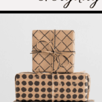 Stack of four gifts wrapped in brown paper with black patterns and twine, set against a pristine white background. Above the gifts, the bold and cursive text reads Celebrate Everyday, inviting you to embrace lifes joyful moments.