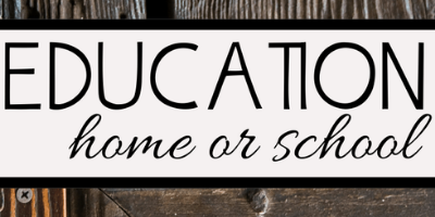 A sign reads EDUCATION home or school in black text on a white background. The sign is set against a wooden backdrop.